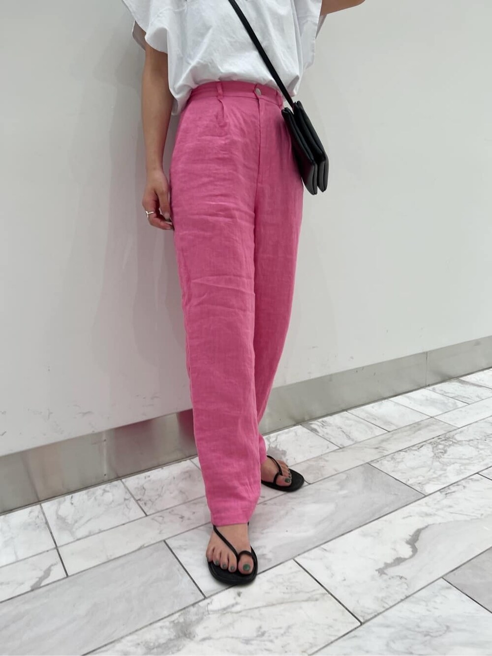 ブラック系のサンダル、ブラック系のショルダーバッグ、ホワイト系のTシャツ/カットソーを着用したレディースの春コーディネートの4枚目の写真