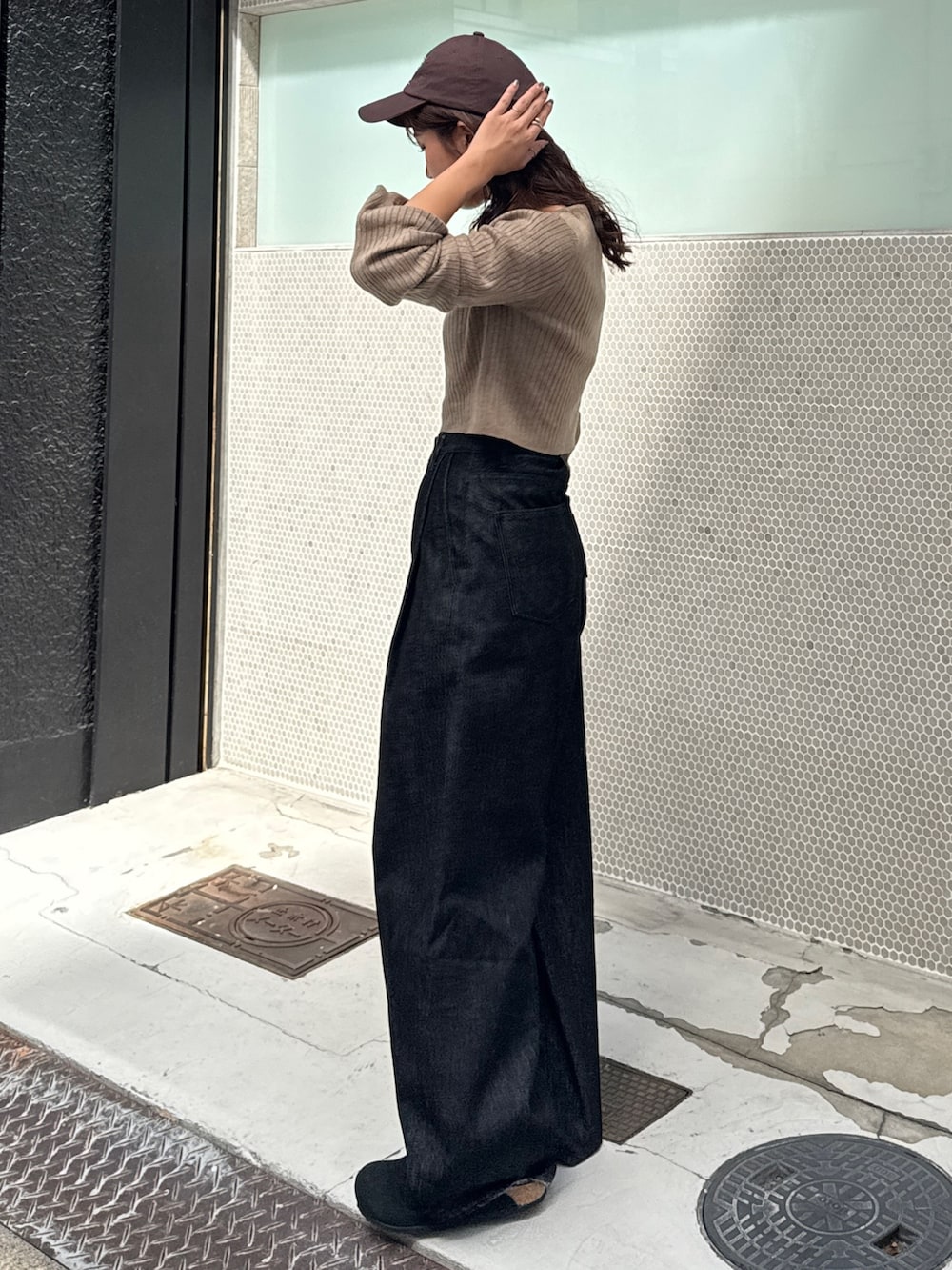 ブラック系のデニムパンツ、グレー系のニット/セーターを着用したレディースの秋コーディネートの4枚目の写真