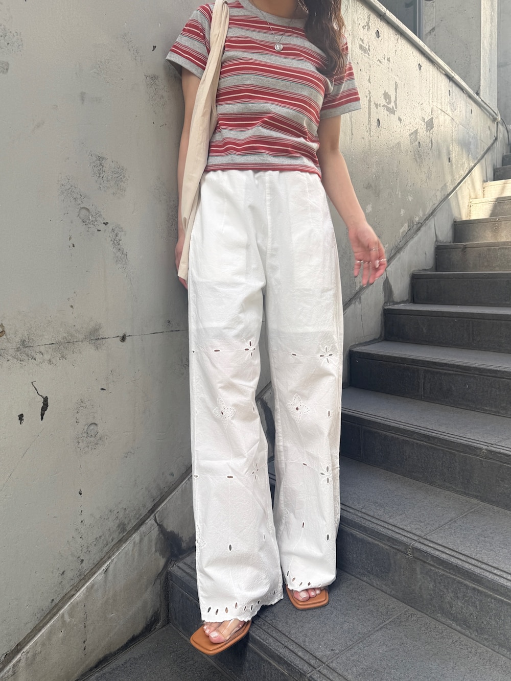ホワイト系のその他パンツ、レッド系のTシャツ/カットソー、その他のサンダルを着用したレディースの春コーディネートの2枚目の写真
