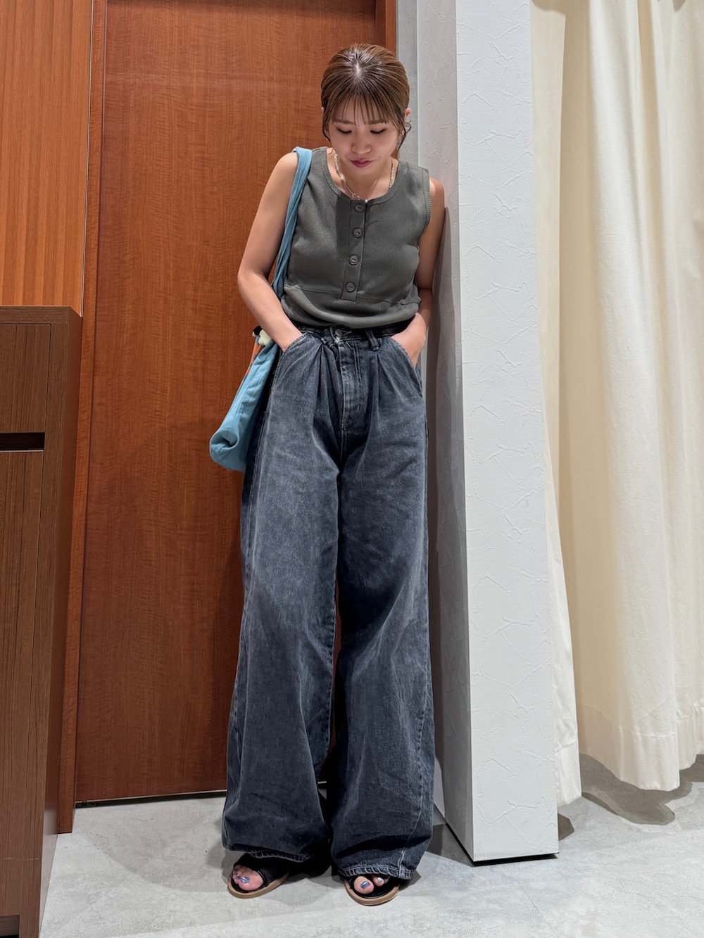 ブラック系のデニムパンツ、グレー系のタンクトップ、ブルー系のトートバッグを着用したレディースの夏コーディネートの5枚目の写真