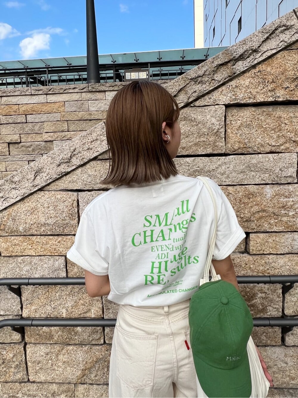 ホワイト系のデニムパンツ、ホワイト系のTシャツ/カットソー、グリーン系のキャップを着用したレディースの春コーディネートの6枚目の写真