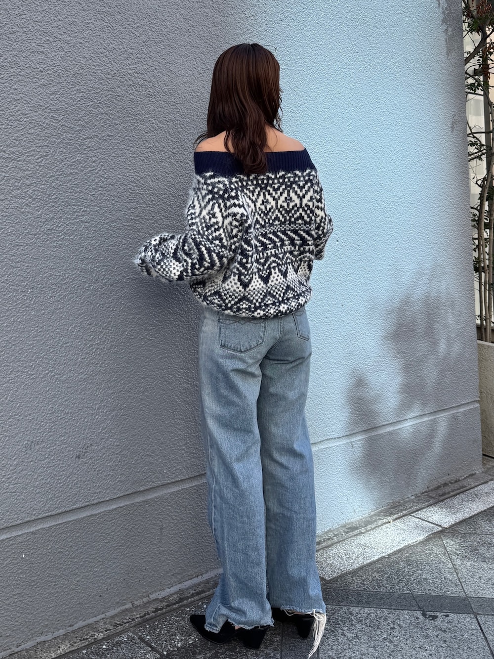 ブルー系のニット/セーター、ブルー系のデニムパンツを着用したレディースの秋コーディネートの5枚目の写真