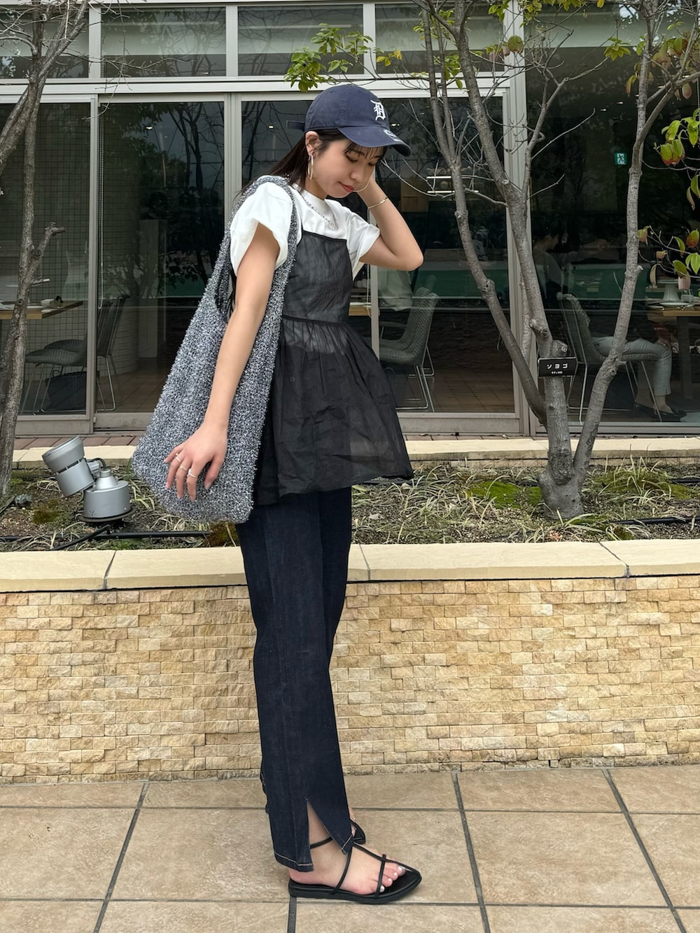 ブルー系のデニムパンツ、ホワイト系のTシャツ/カットソー、ブラック系のキャミソールを着用したレディースの春コーディネートの5枚目の写真