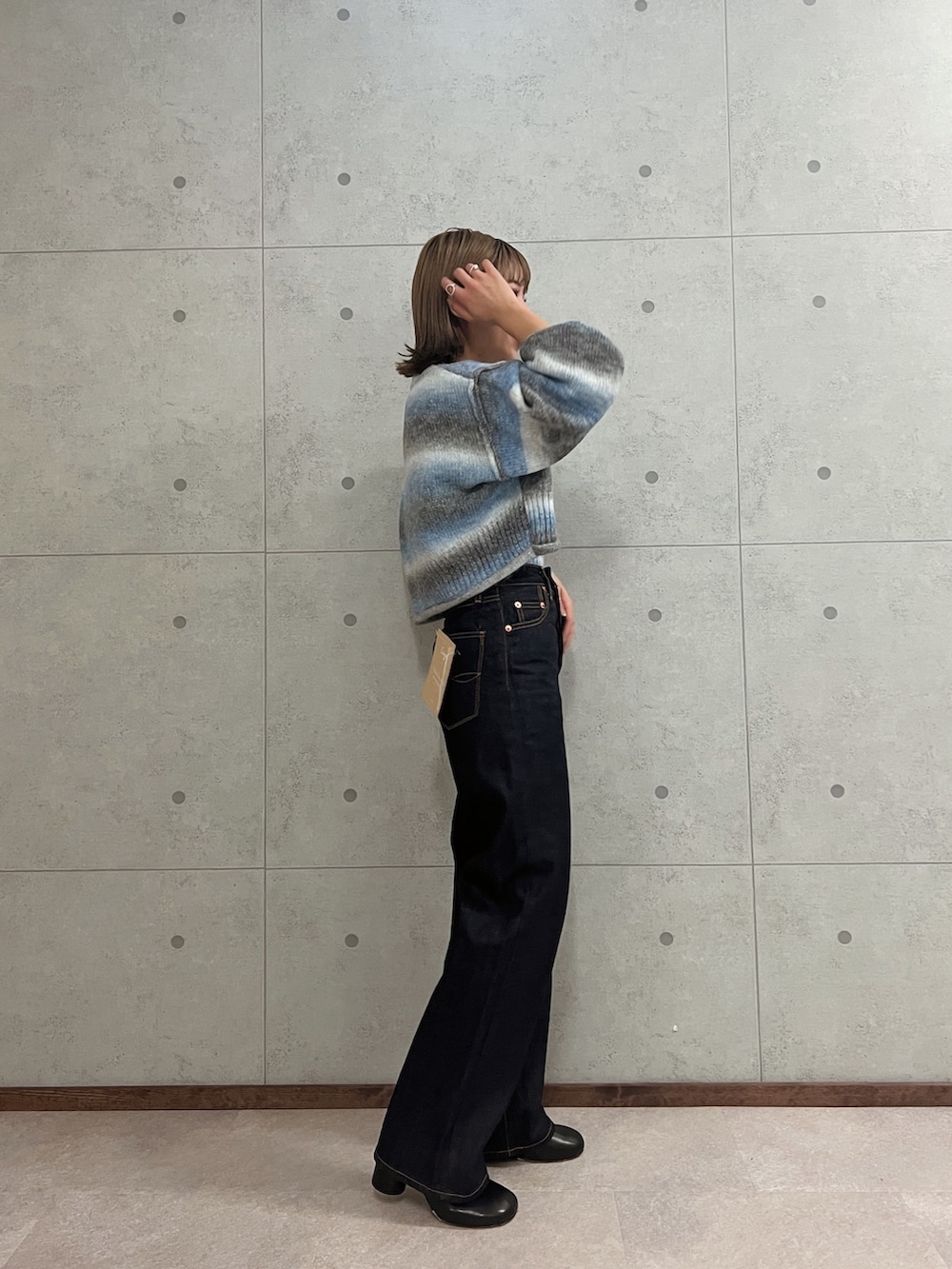 ブルー系のデニムパンツ、ブルー系のニット/セーターを着用したレディースの秋コーディネートの4枚目の写真