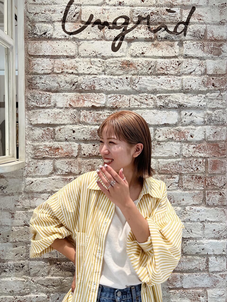 ホワイト系のキャミソール、ブルー系のデニムパンツ、イエロー系のシャツ/ブラウスを着用したレディースの夏コーディネートの3枚目の写真