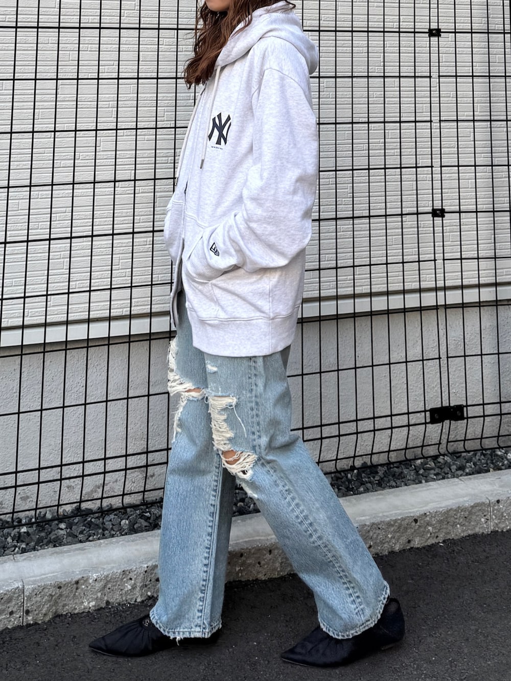 グレー系のパーカー、ブルー系のデニムパンツ、ブラック系のパンプスを着用したレディースの春コーディネートの4枚目の写真