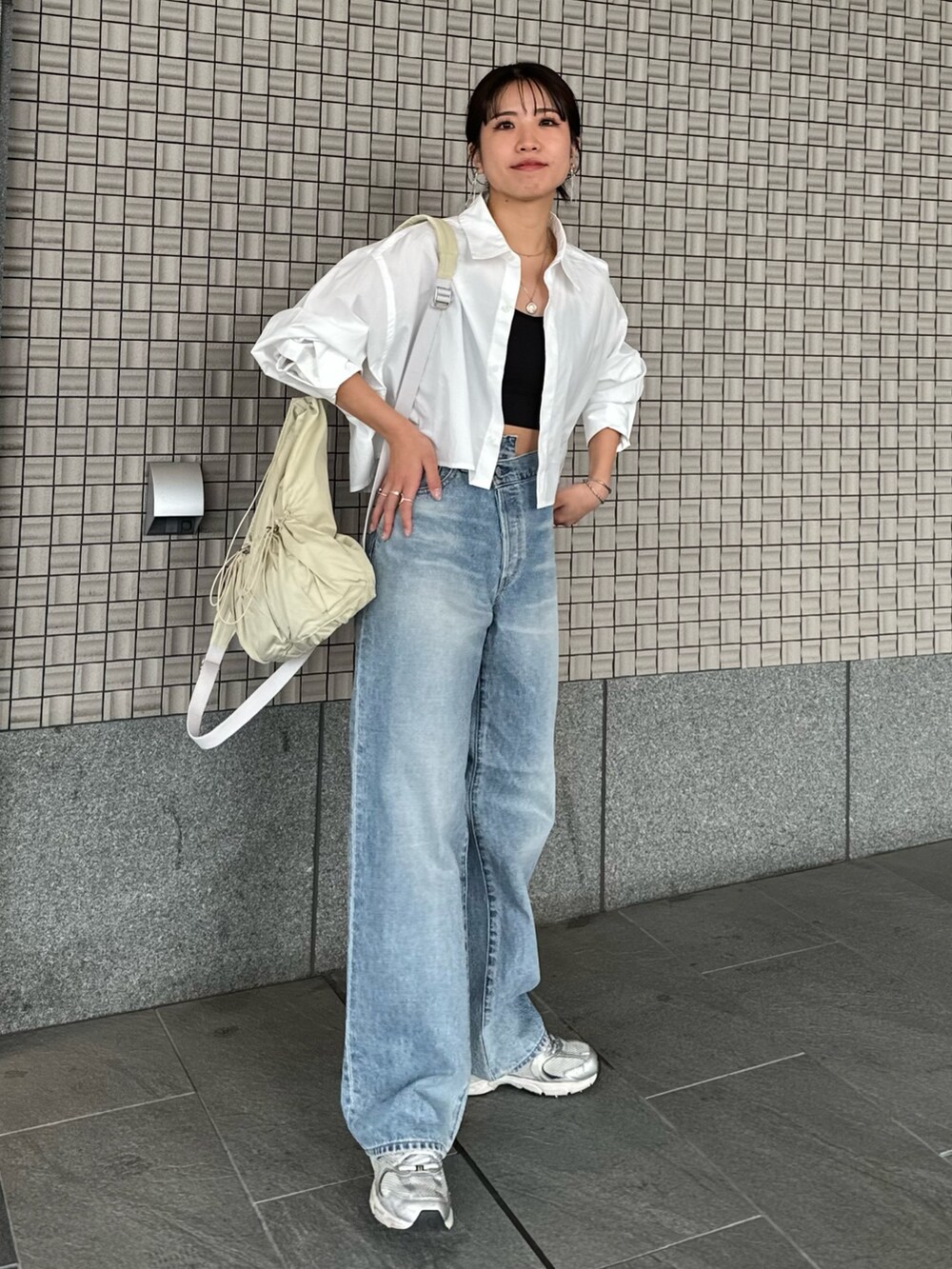 ブルー系のデニムパンツ、ホワイト系のシャツ/ブラウス、ブラック系のキャミソールを着用したレディースの春コーディネートの3枚目の写真