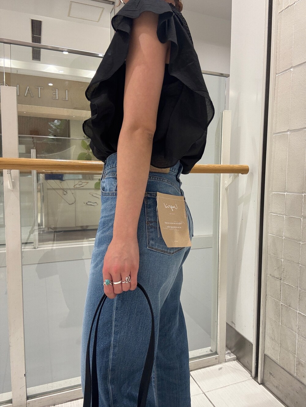 ブルー系のデニムパンツ、ブラック系のシャツ/ブラウス、ブラック系のハンドバッグを着用したレディースの春コーディネートの10枚目の写真