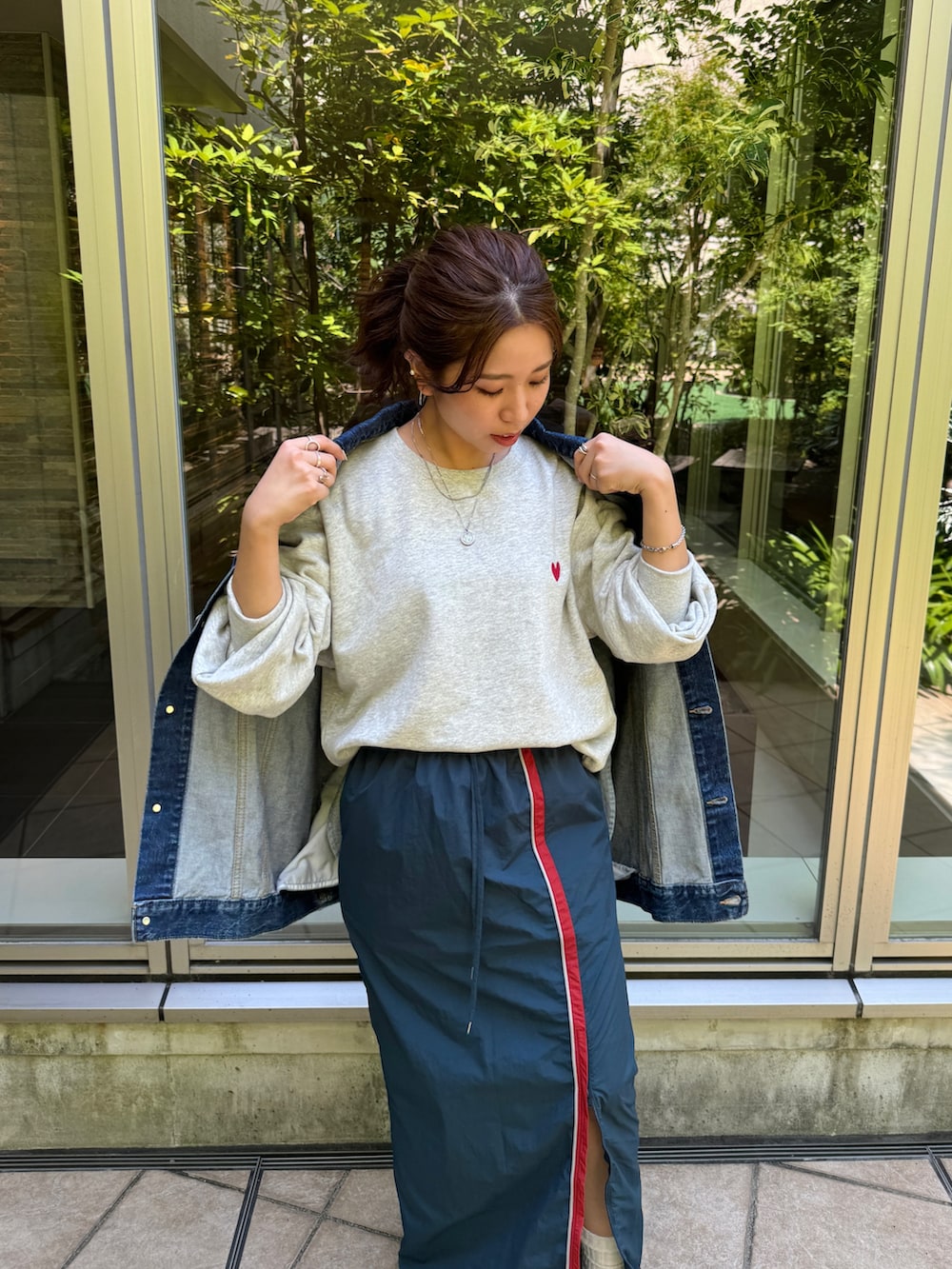 ブルー系のスカート、グレー系のスウェット、ブルー系のデニムジャケットを着用したレディースの夏コーディネートの6枚目の写真