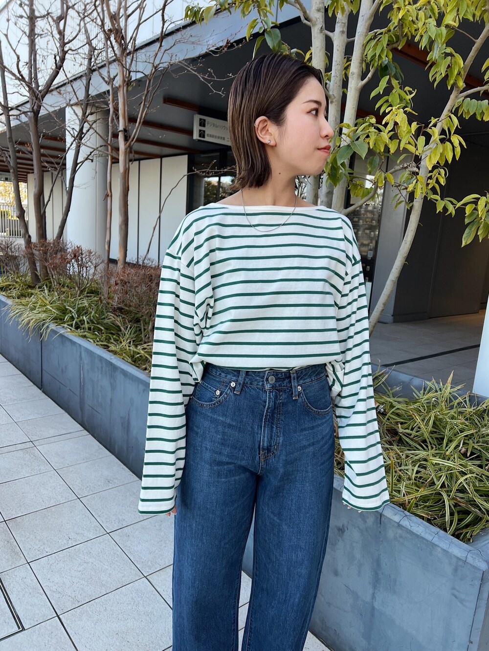 ブルー系のデニムパンツ、グリーン系のTシャツ/カットソーを着用したレディースの冬コーディネートの5枚目の写真