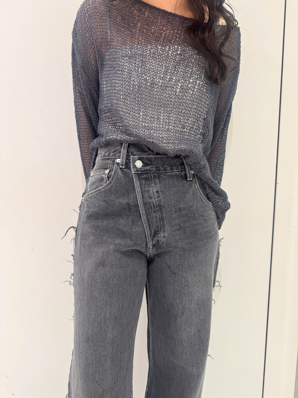 ブラック系のデニムパンツ、グレー系のニット/セーター、ブラック系のサンダルを着用したレディースの秋コーディネートの6枚目の写真