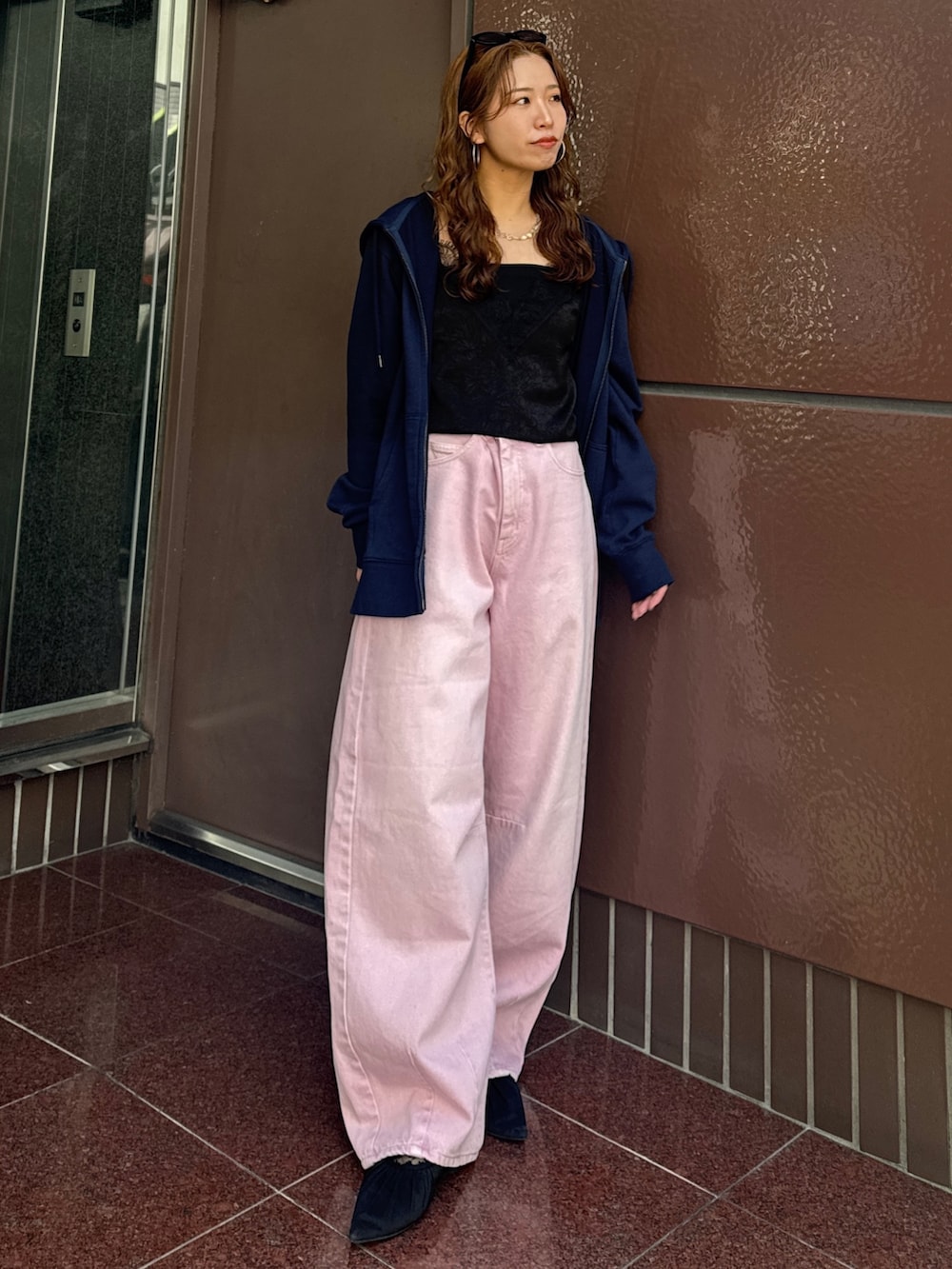 ブルー系のパーカー、ピンク系のデニムパンツ、ブラック系のキャミソールを着用したレディースの春コーディネートの5枚目の写真