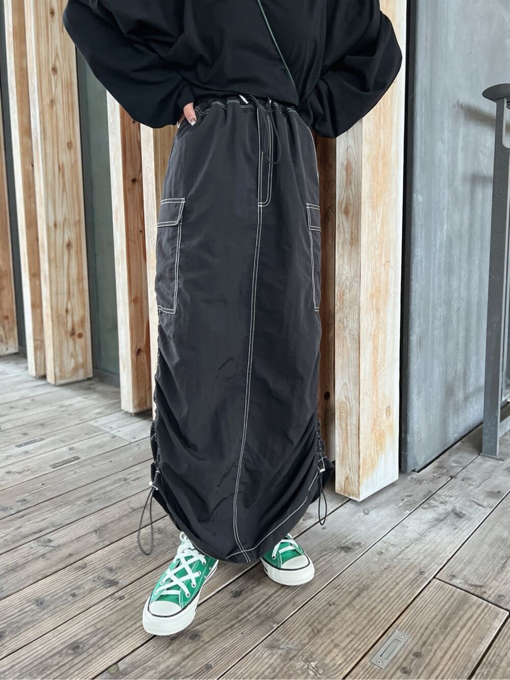 グリーン系のハンドバッグ、ブラック系のTシャツ/カットソー、ブラック系のスカートを着用したレディースの夏コーディネートの8枚目の写真