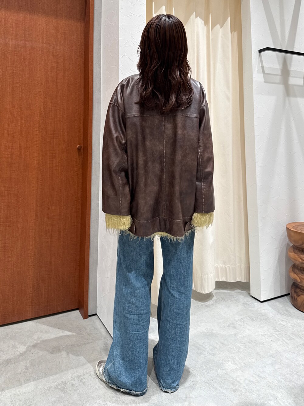 ブルー系のデニムパンツ、イエロー系のカーディガン/ボレロ、ブラウン系のブルゾンを着用したレディースの秋コーディネートの5枚目の写真