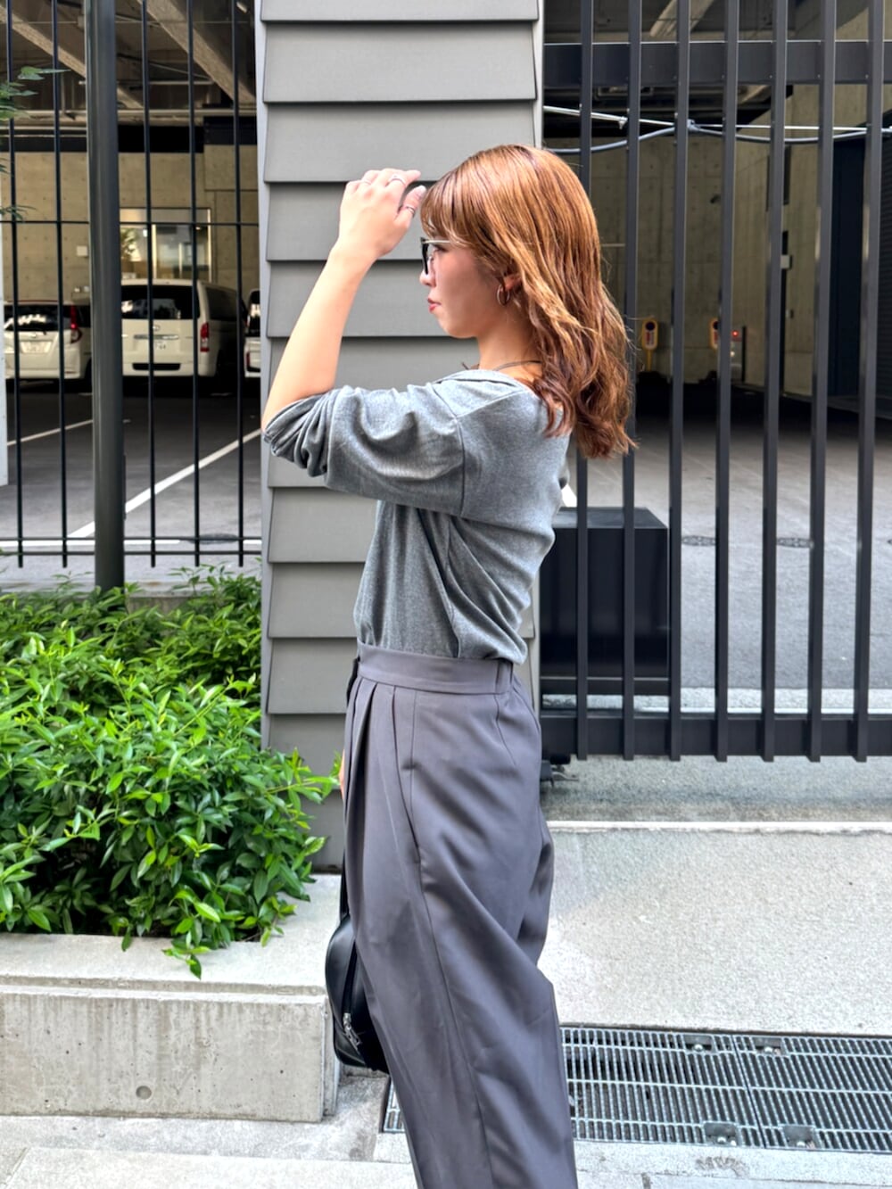 グレー系のその他パンツ、ベージュ系のスリッポン、ブラック系のハンドバッグを着用したレディースの夏コーディネートの9枚目の写真