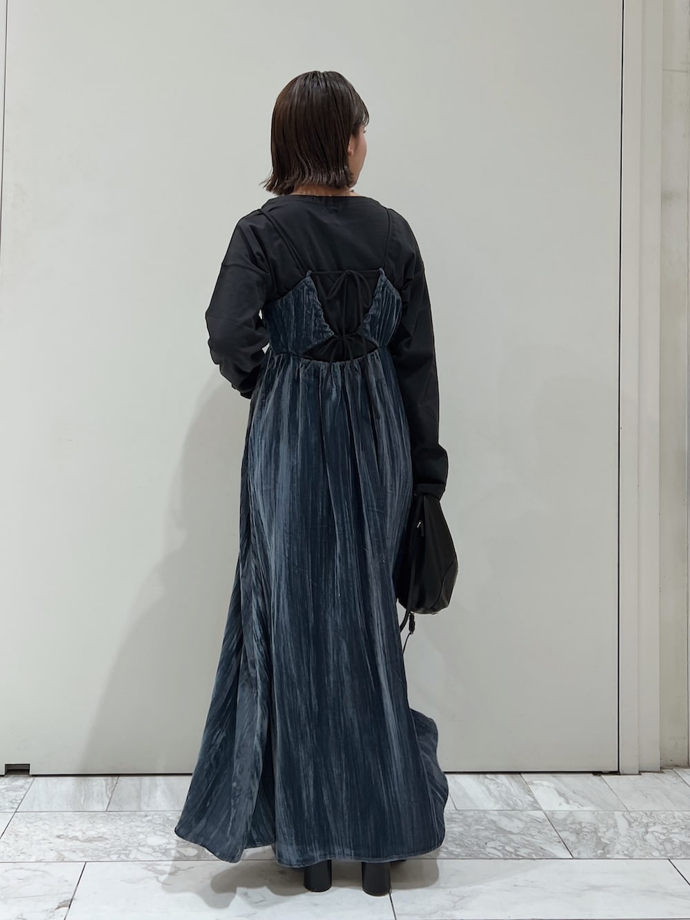 ブルー系のワンピース、ブラック系のTシャツ/カットソー、ブラック系のブーツを着用したレディースの冬コーディネートの5枚目の写真