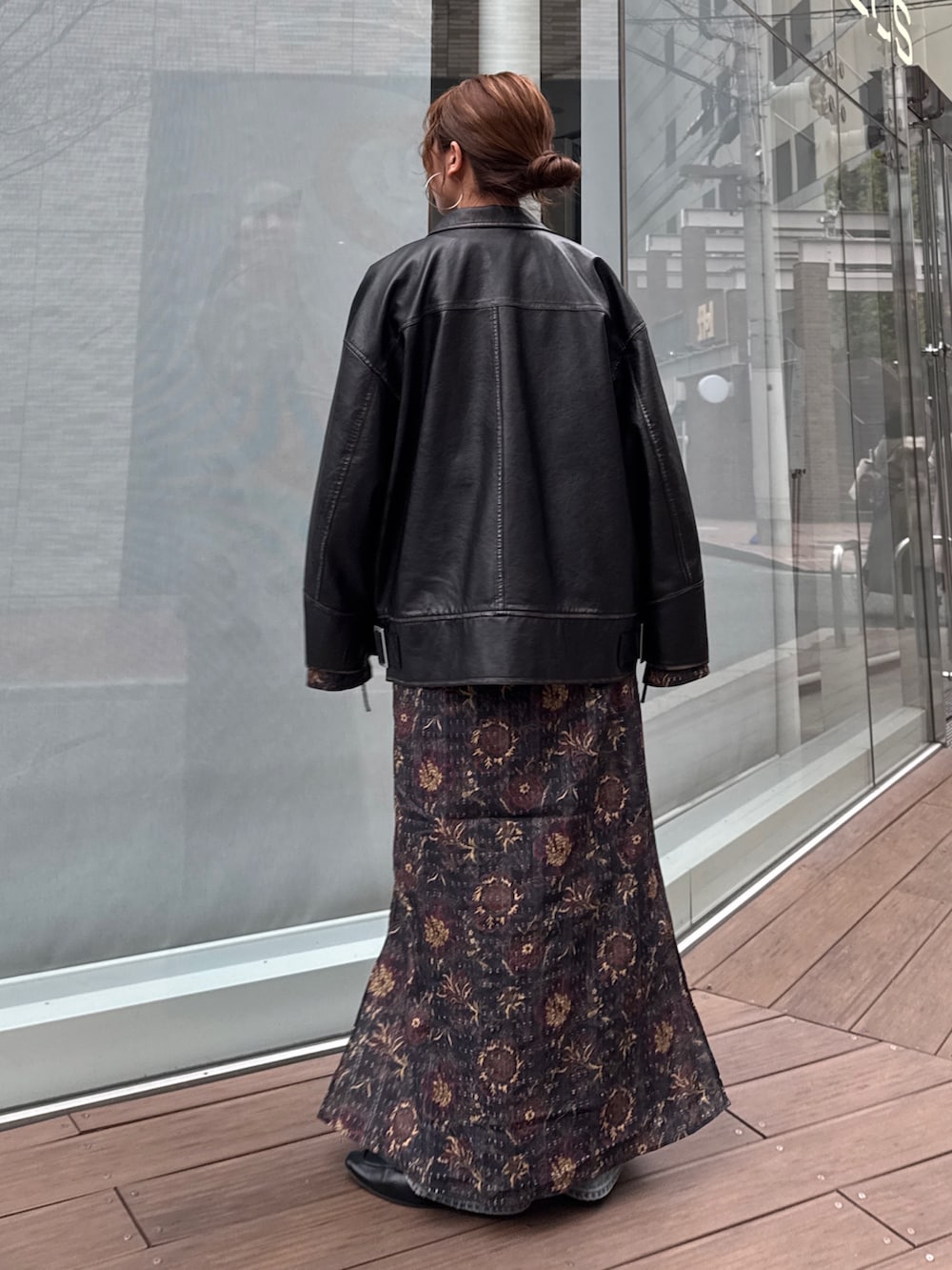 ブラック系のブルゾン、ブラック系のワンピース、ブルー系のデニムパンツを着用したレディースの冬コーディネートの6枚目の写真