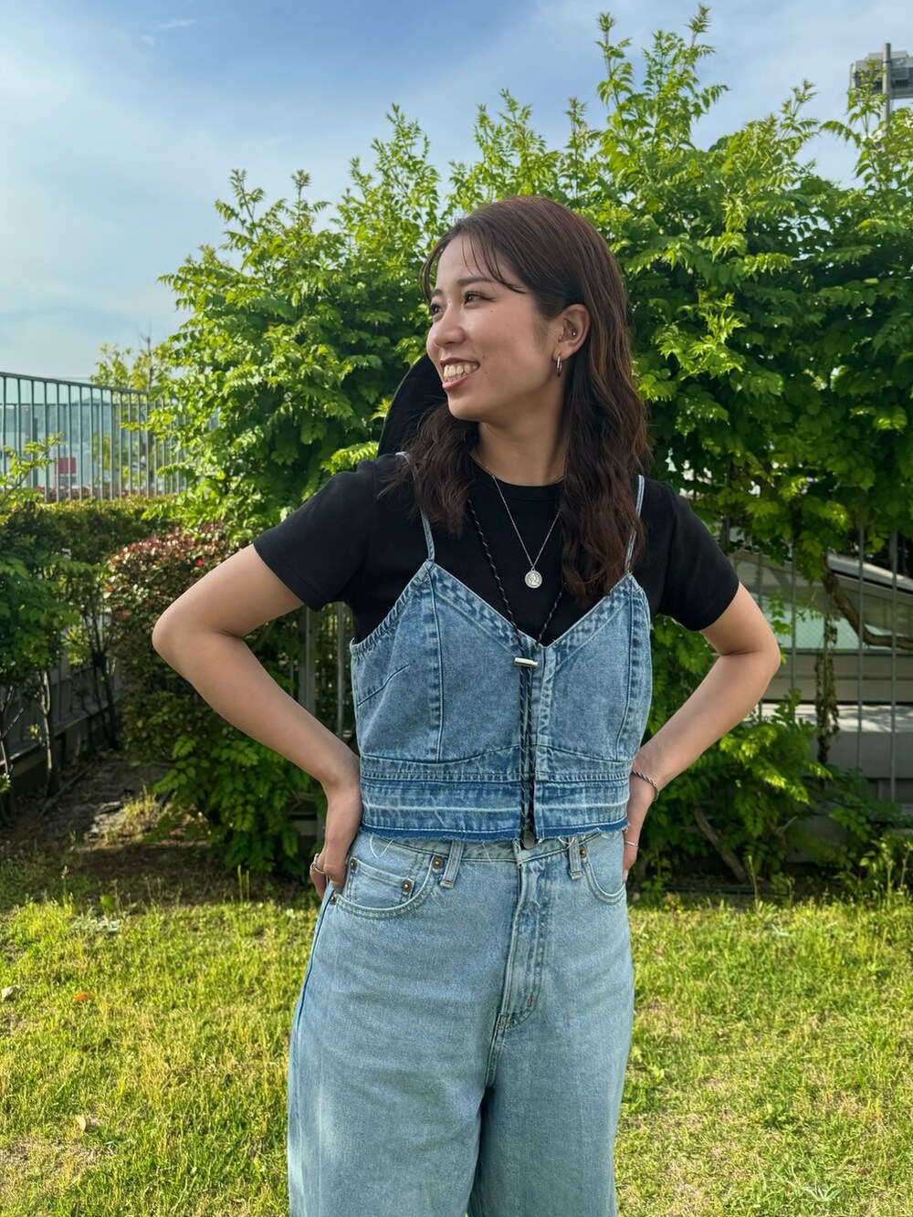 ブルー系のキャミソール、ブルー系のデニムパンツ、ブラック系のTシャツ/カットソーを着用したレディースの夏コーディネートの4枚目の写真