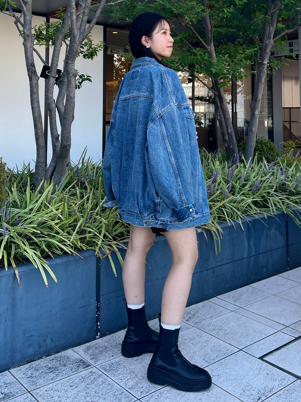 ブルー系のスウェット、ブルー系のデニムジャケット、ブラック系のハンチング/ベレー帽を着用したレディースの秋コーディネートの6枚目の写真