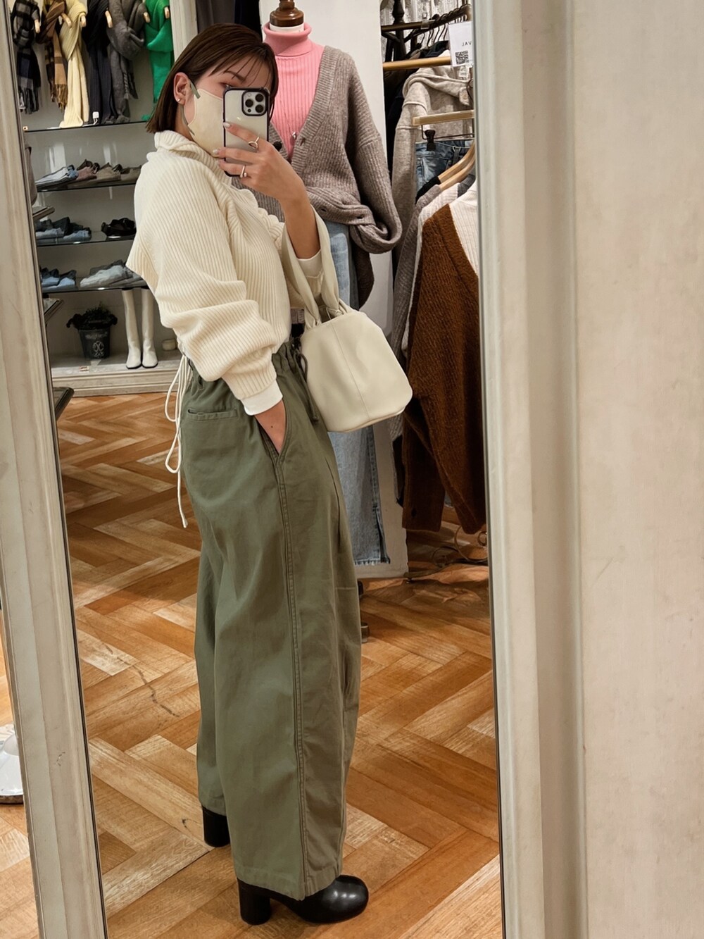 ホワイト系のワンピース、ブラック系のブーツ、ホワイト系のTシャツ/カットソーを着用したレディースの冬コーディネートの2枚目の写真