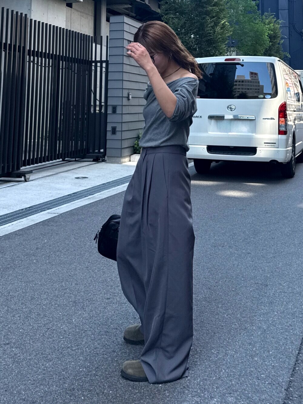 グレー系のその他パンツ、ベージュ系のスリッポン、ブラック系のハンドバッグを着用したレディースの夏コーディネートの5枚目の写真