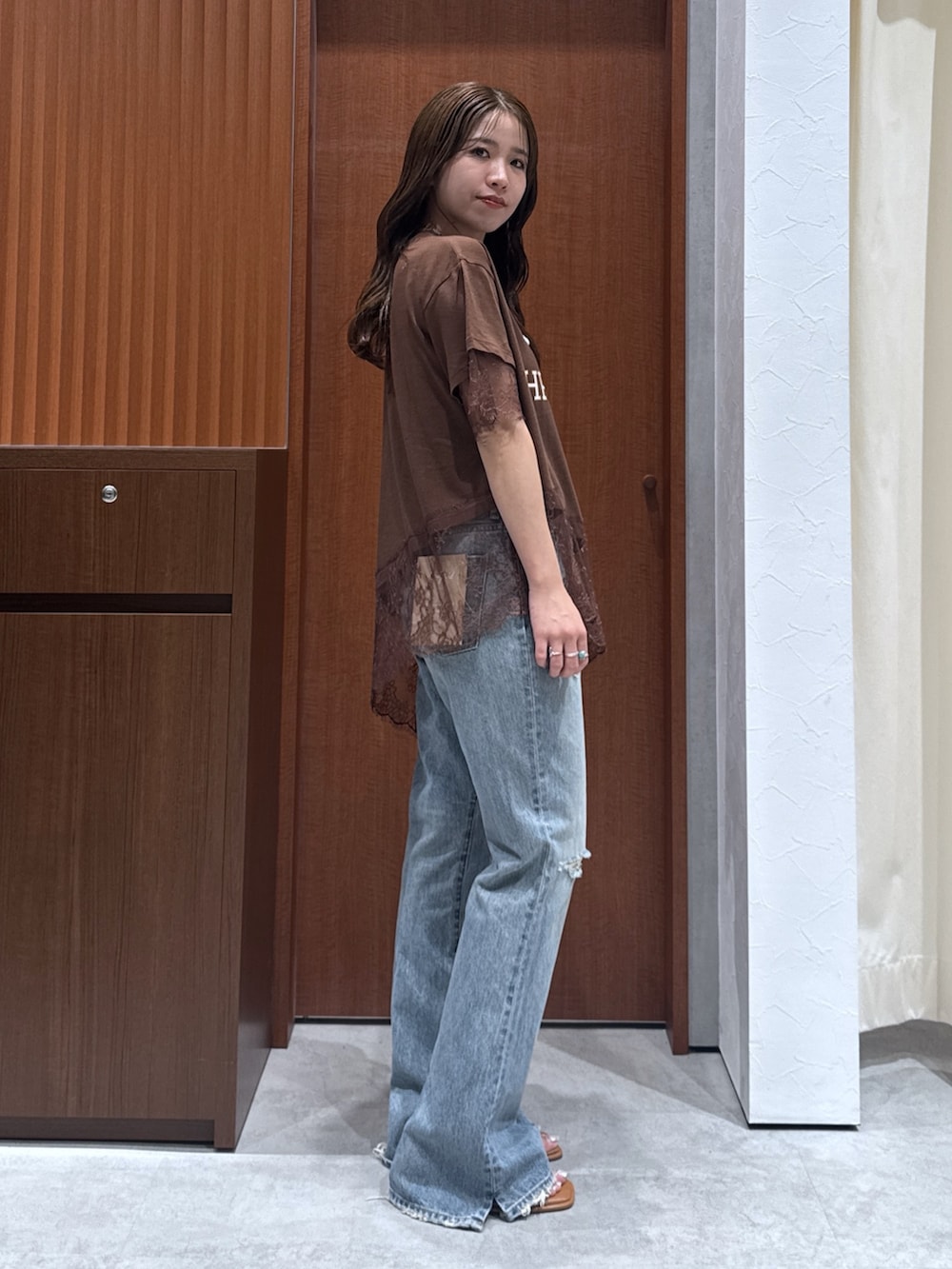 ブラウン系のTシャツ/カットソー、ブルー系のデニムパンツ、その他のサンダルを着用したレディースの夏コーディネートの2枚目の写真