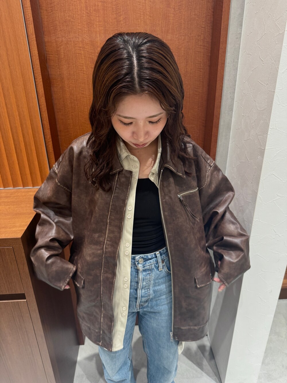 ブラウン系のブルゾン、ホワイト系のシャツ/ブラウス、ブルー系のデニムパンツを着用したレディースの秋コーディネートの8枚目の写真