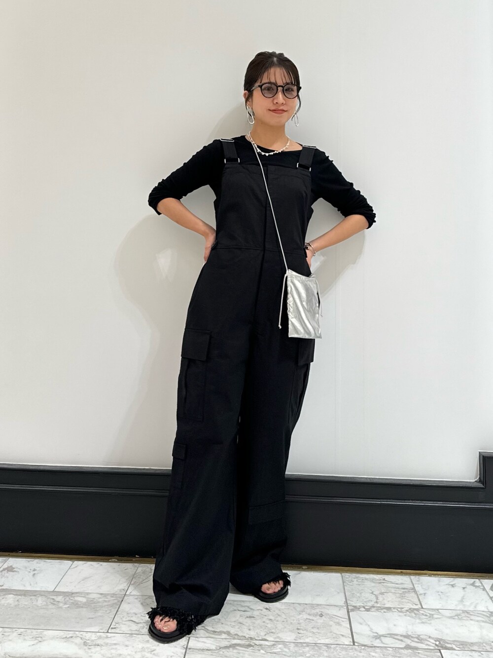 ブラック系のつなぎ/オールインワン、ブラック系のTシャツ/カットソー、ブラック系のサンダルを着用したレディースの冬コーディネートの7枚目の写真