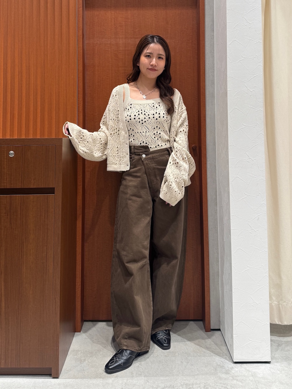 ブラウン系のデニムパンツ、ホワイト系のアンサンブル、ブラック系のその他シューズを着用したレディースの秋コーディネートの10枚目の写真