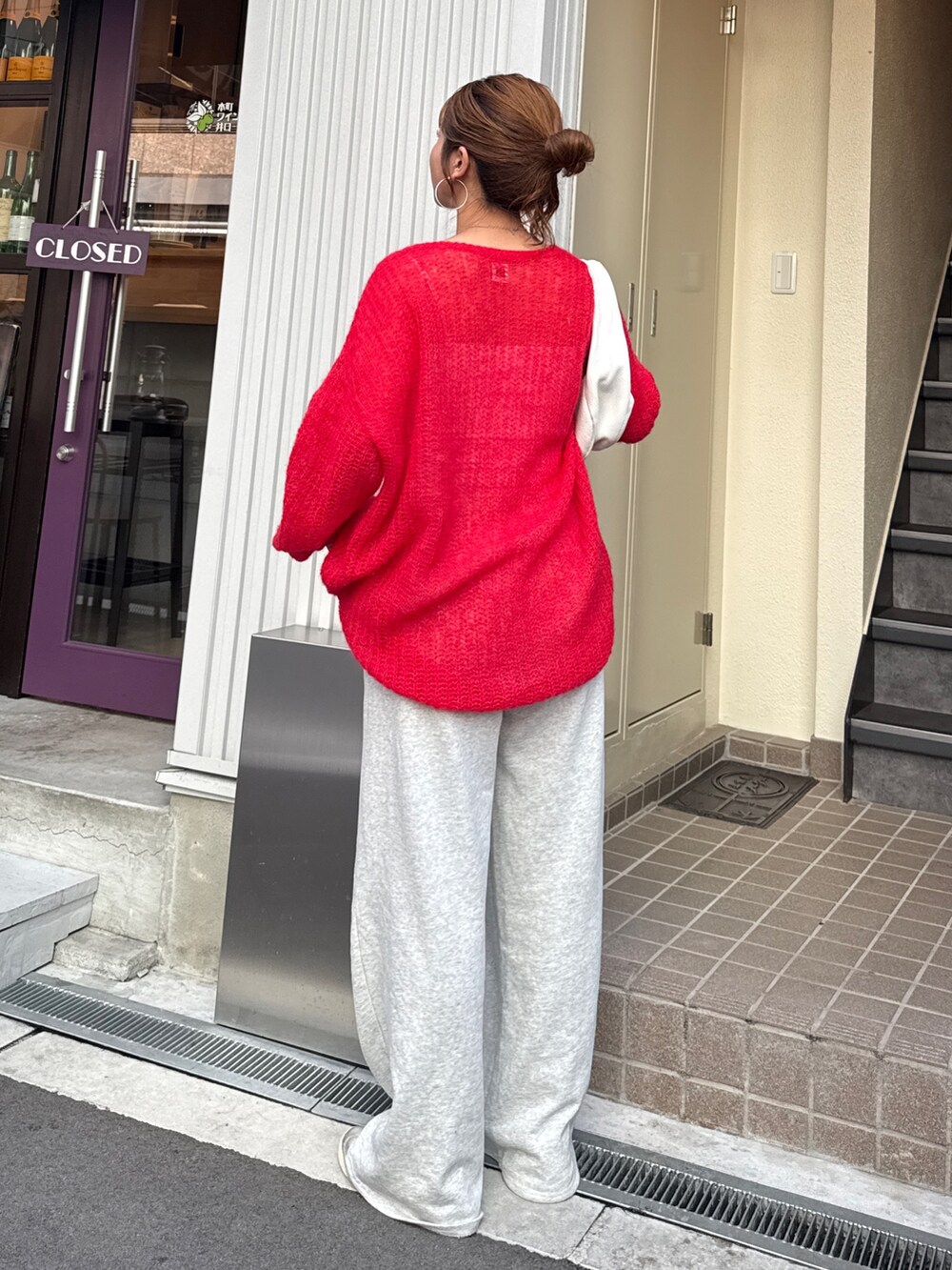 グレー系のスウェットパンツ、レッド系のニット/セーターを着用したレディースの秋コーディネートの3枚目の写真