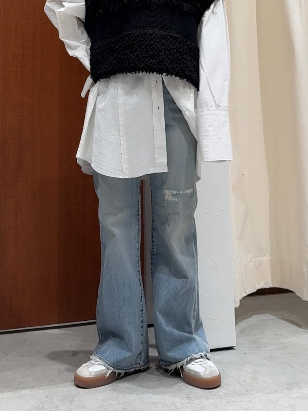 ブラック系のベスト、ホワイト系のシャツ/ブラウス、ブルー系のデニムパンツを着用したレディースの春コーディネートの6枚目の写真