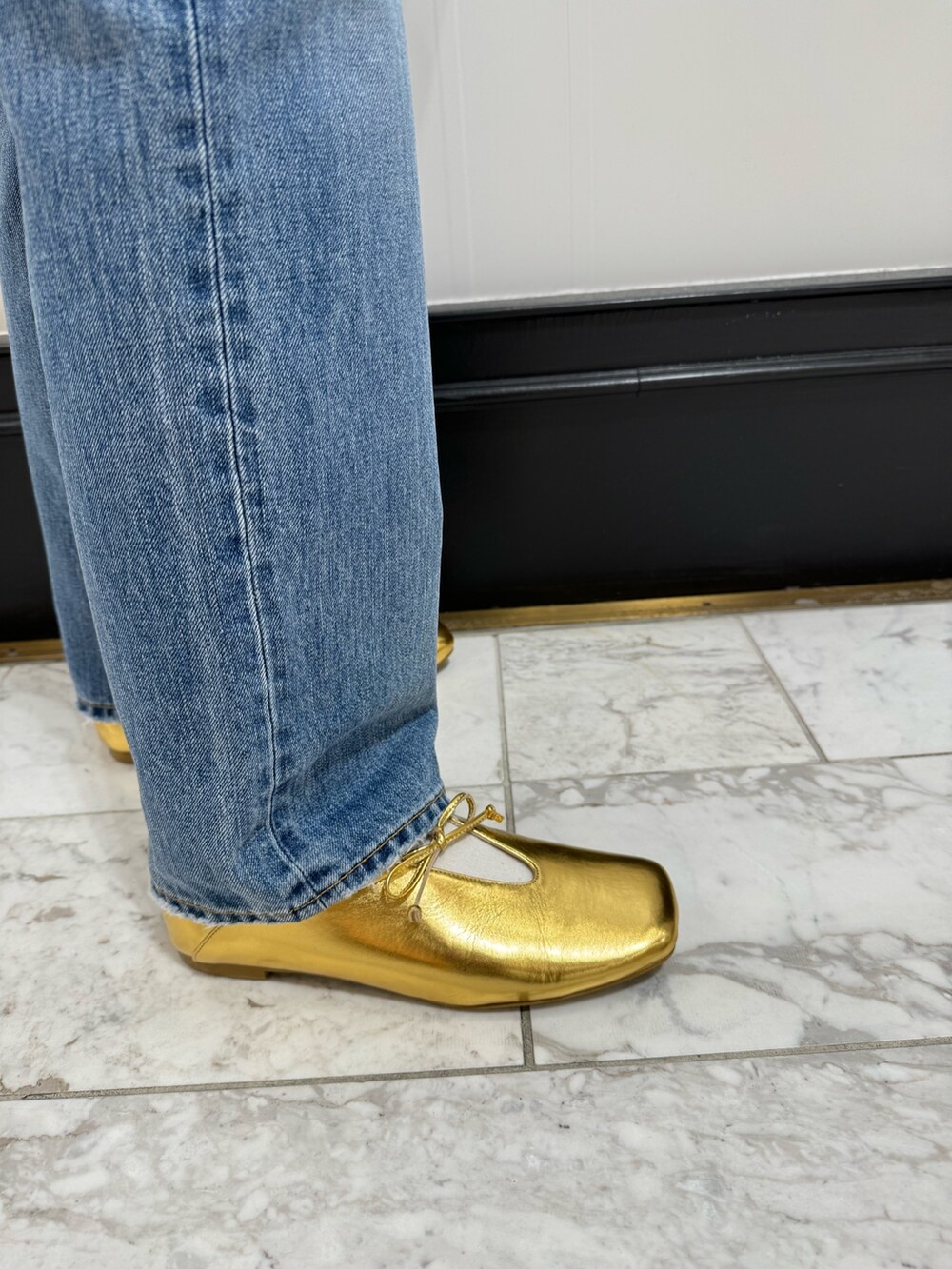 グリーン系のカーディガン/ボレロ、ホワイト系のハンドバッグ、ブルー系のデニムパンツを着用したレディースの冬コーディネートの10枚目の写真