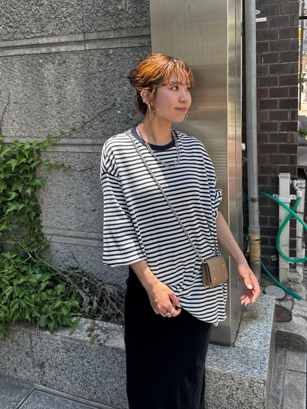 ブルー系のTシャツ/カットソー、ブラック系のスカート、ブラック系のスリッポンを着用したレディースの夏コーディネートの5枚目の写真