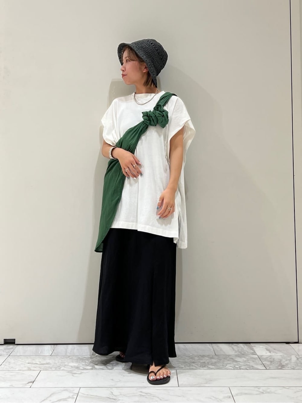 ブラック系のサンダル、ホワイト系のTシャツ/カットソー、グリーン系のシャツ/ブラウスを着用したレディースの夏コーディネートの2枚目の写真