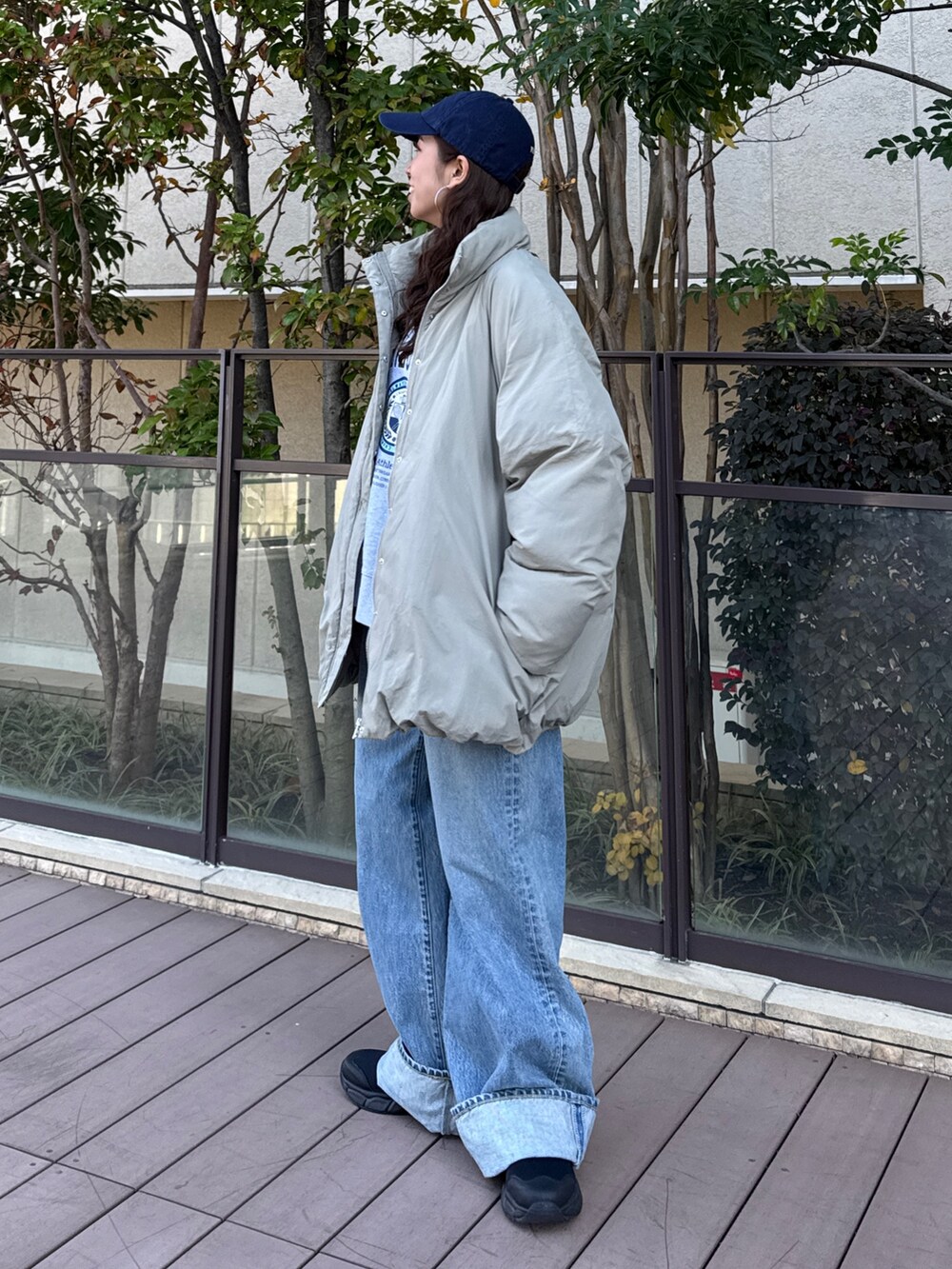 ベージュ系のブルゾン、グレー系のスウェット、ブルー系のデニムパンツを着用したレディースの冬コーディネートの2枚目の写真