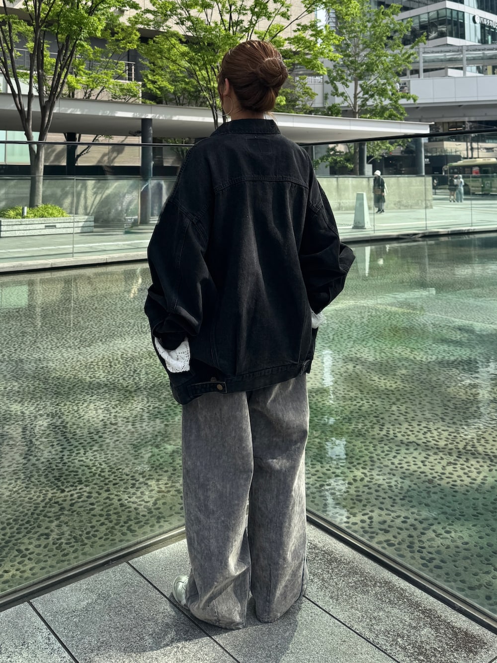 ホワイト系のニット/セーター、ベージュ系のデニムパンツ、ブラック系のデニムジャケットを着用したレディースの夏コーディネートの4枚目の写真