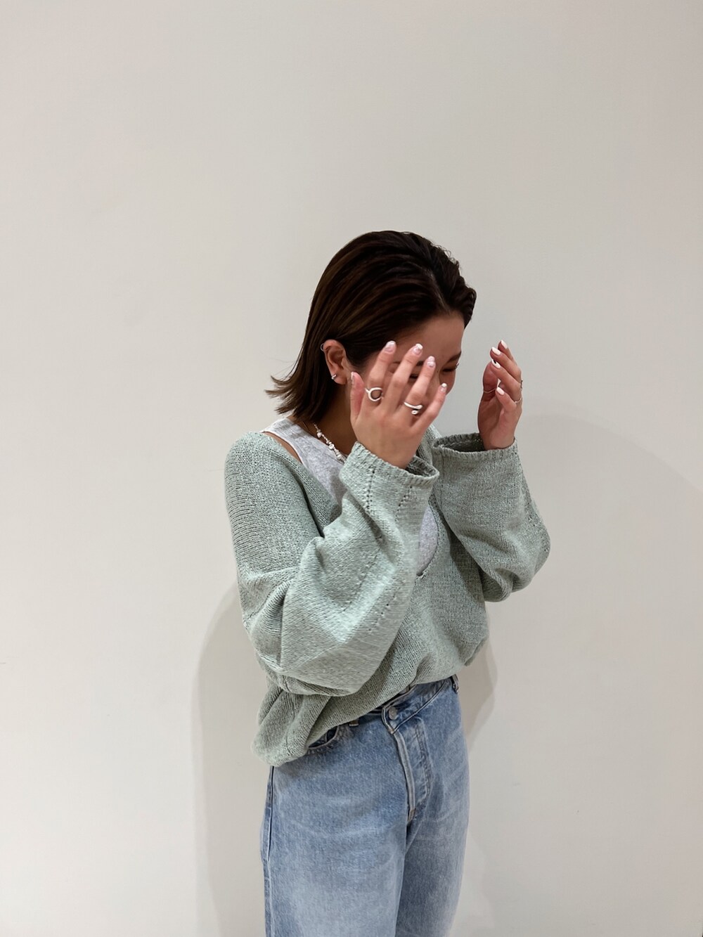 ブルー系のデニムパンツ、イエロー系のパンプス、グリーン系のニット/セーターを着用したレディースの冬コーディネートの8枚目の写真