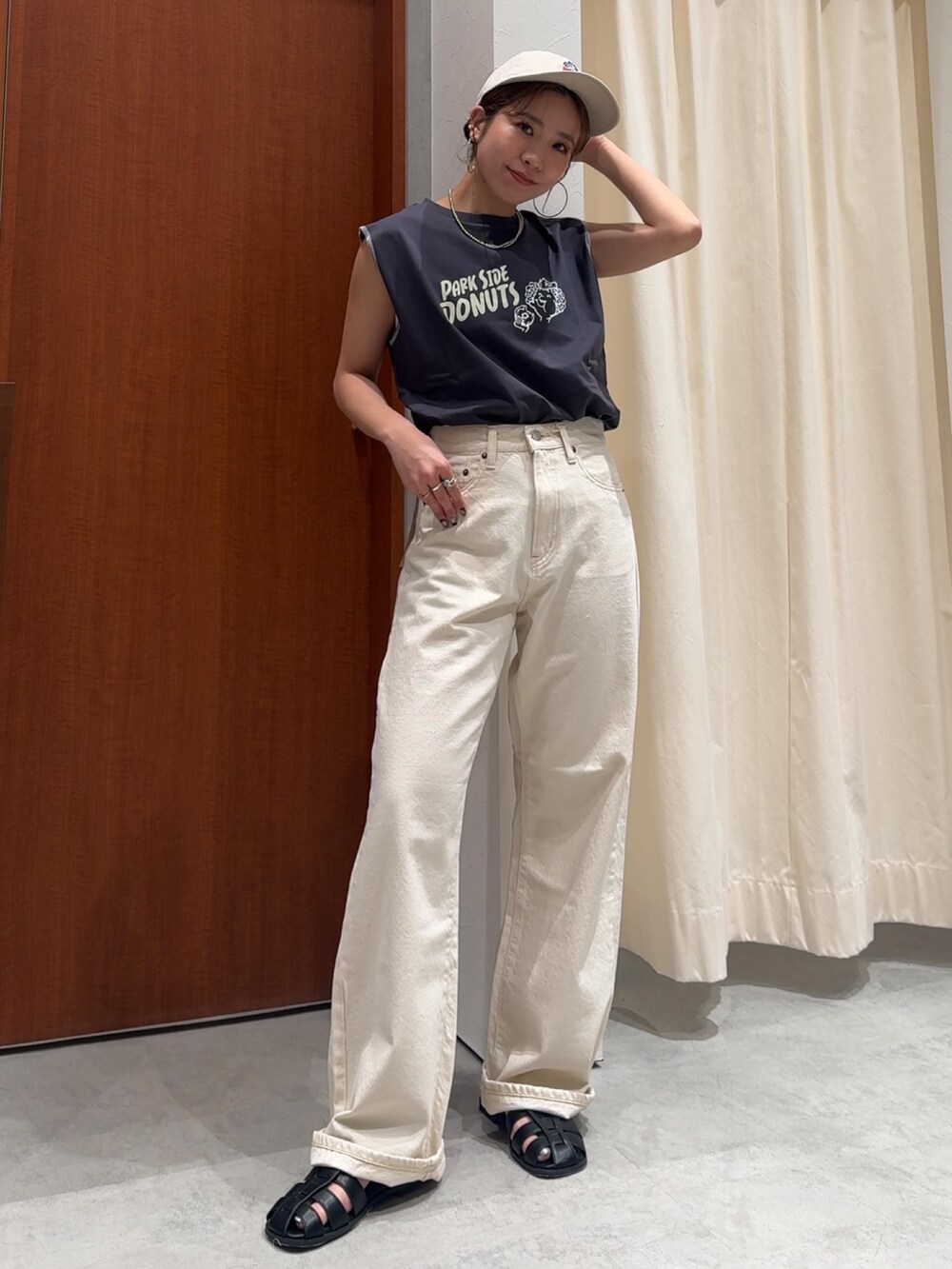 ホワイト系のデニムパンツ、グレー系のタンクトップ、ブラック系のサンダルを着用したレディースの春コーディネートの7枚目の写真