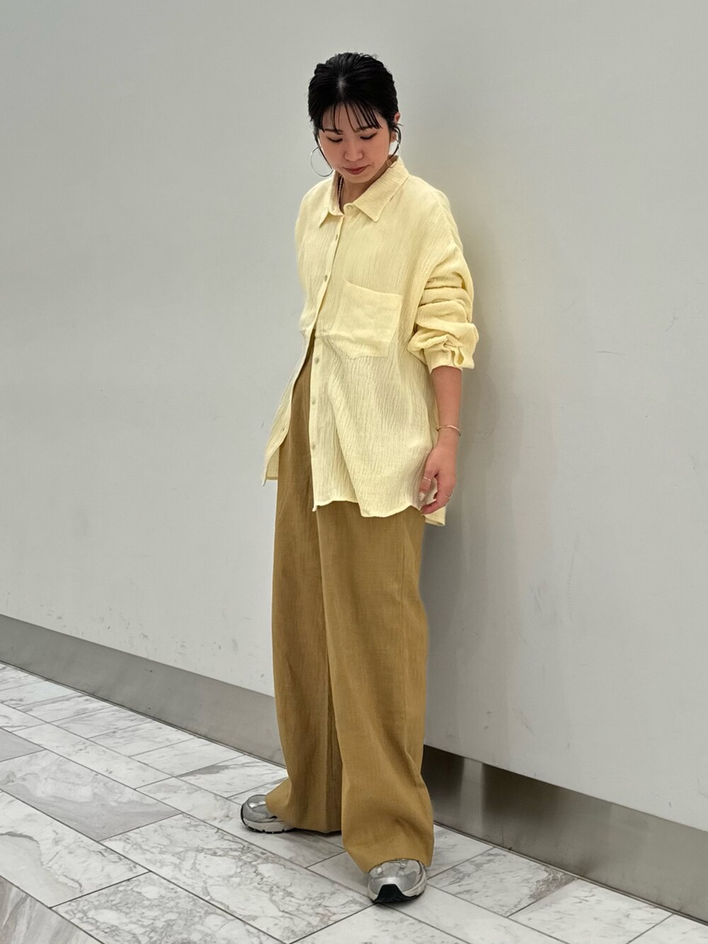 ベージュ系のその他パンツ、ホワイト系のキャミソール、イエロー系のシャツ/ブラウスを着用したレディースの春コーディネートの2枚目の写真