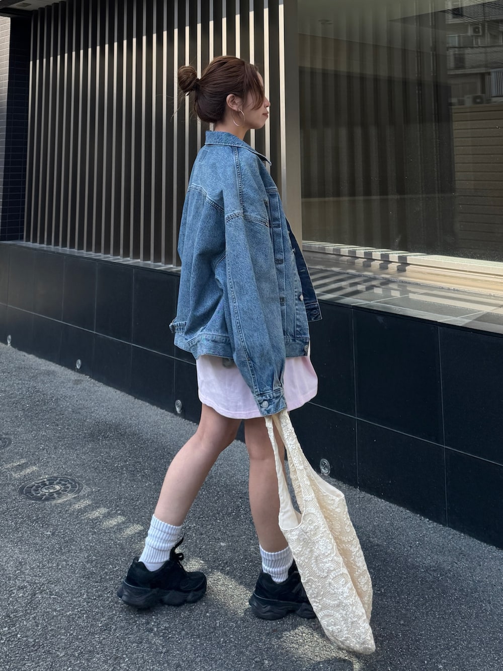 ピンク系のTシャツ/カットソー、ブルー系のデニムジャケット、ブラック系のその他パンツを着用したレディースの春コーディネートの5枚目の写真