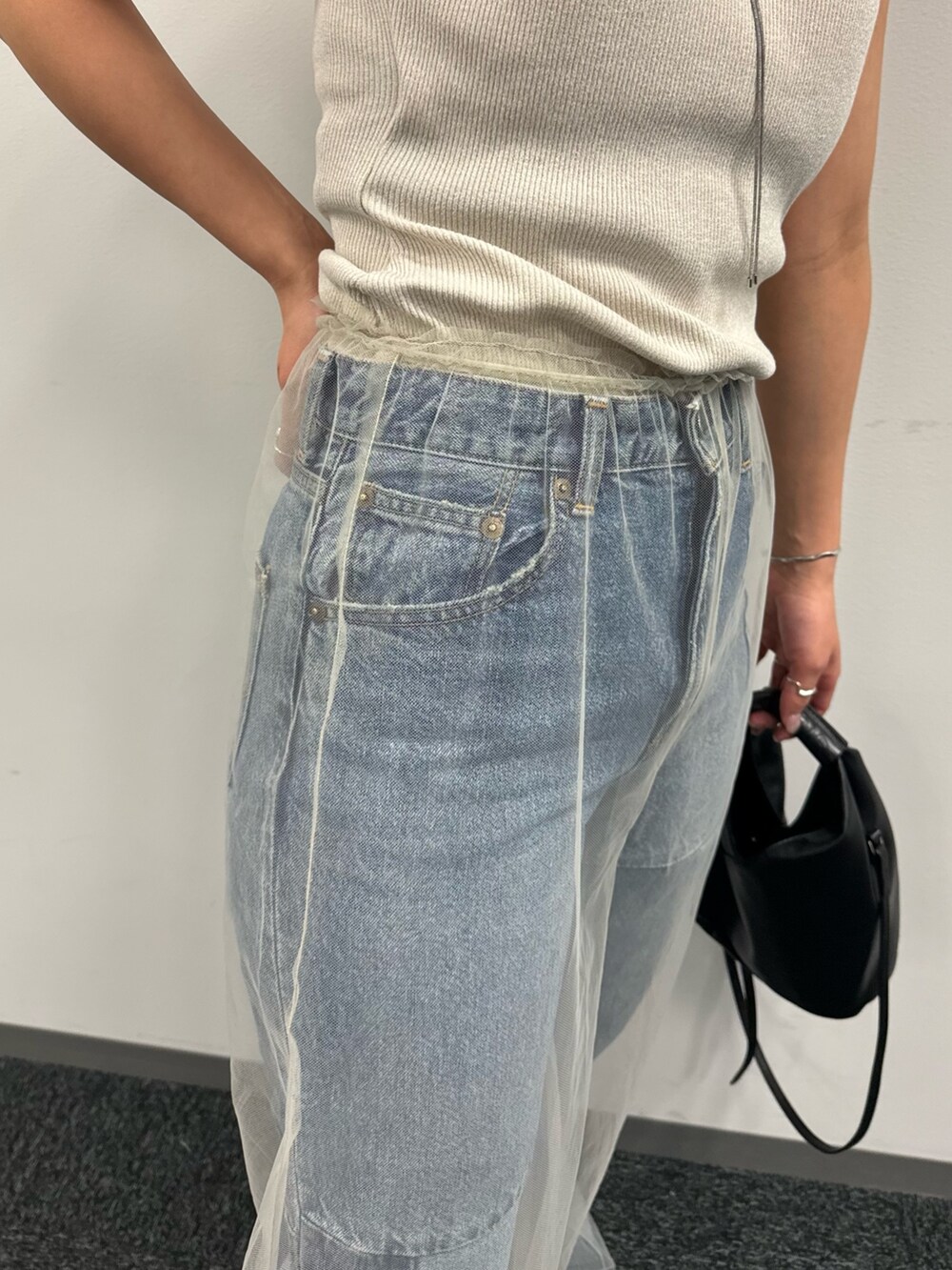 ブルー系のデニムパンツ、ベージュ系のその他パンツ、ホワイト系のタンクトップを着用したレディースの春コーディネートの10枚目の写真