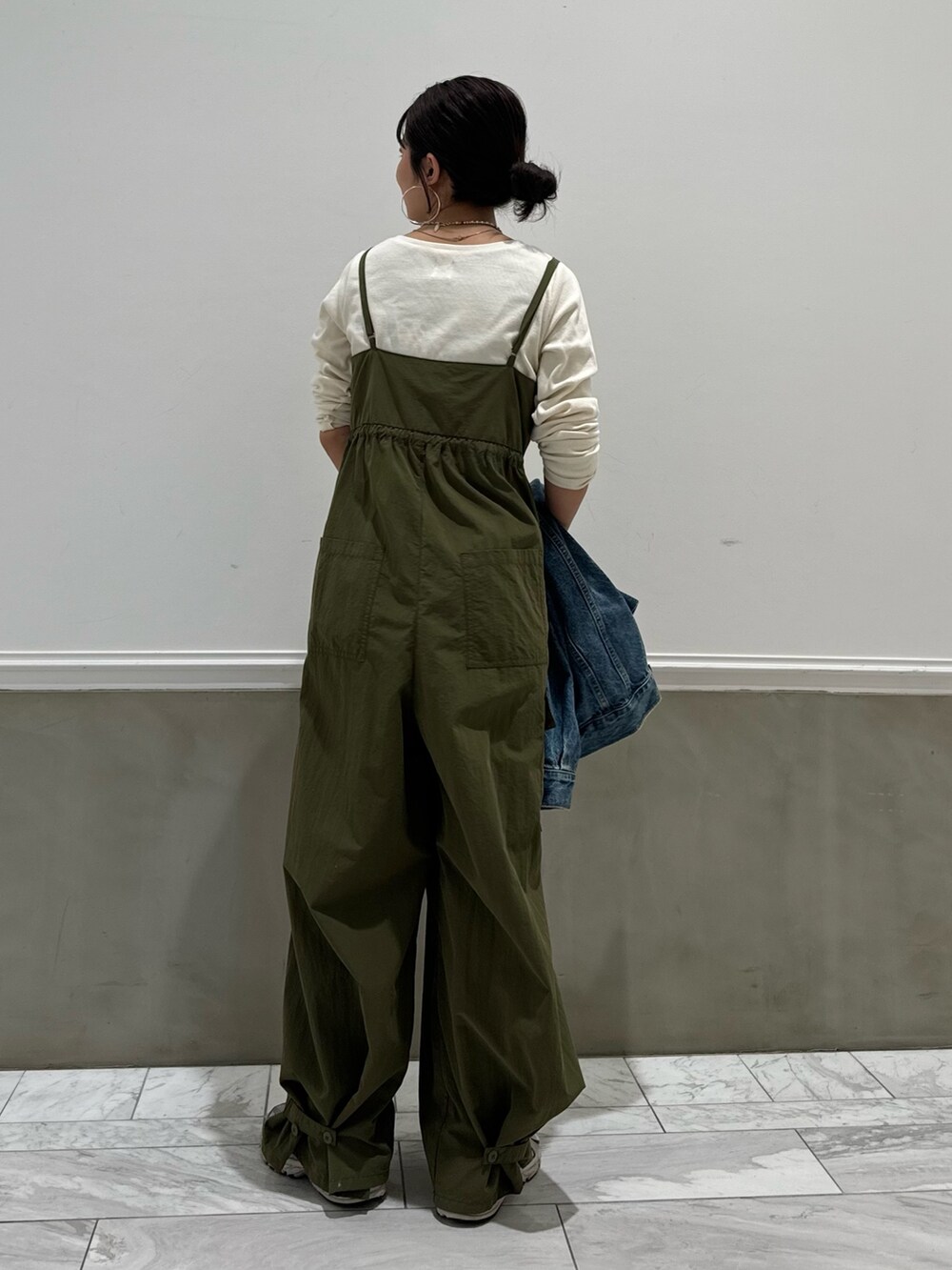 ホワイト系のTシャツ/カットソー、グリーン系のサロペット/オーバーオール、ブルー系のデニムジャケットを着用したレディースの春コーディネートの3枚目の写真