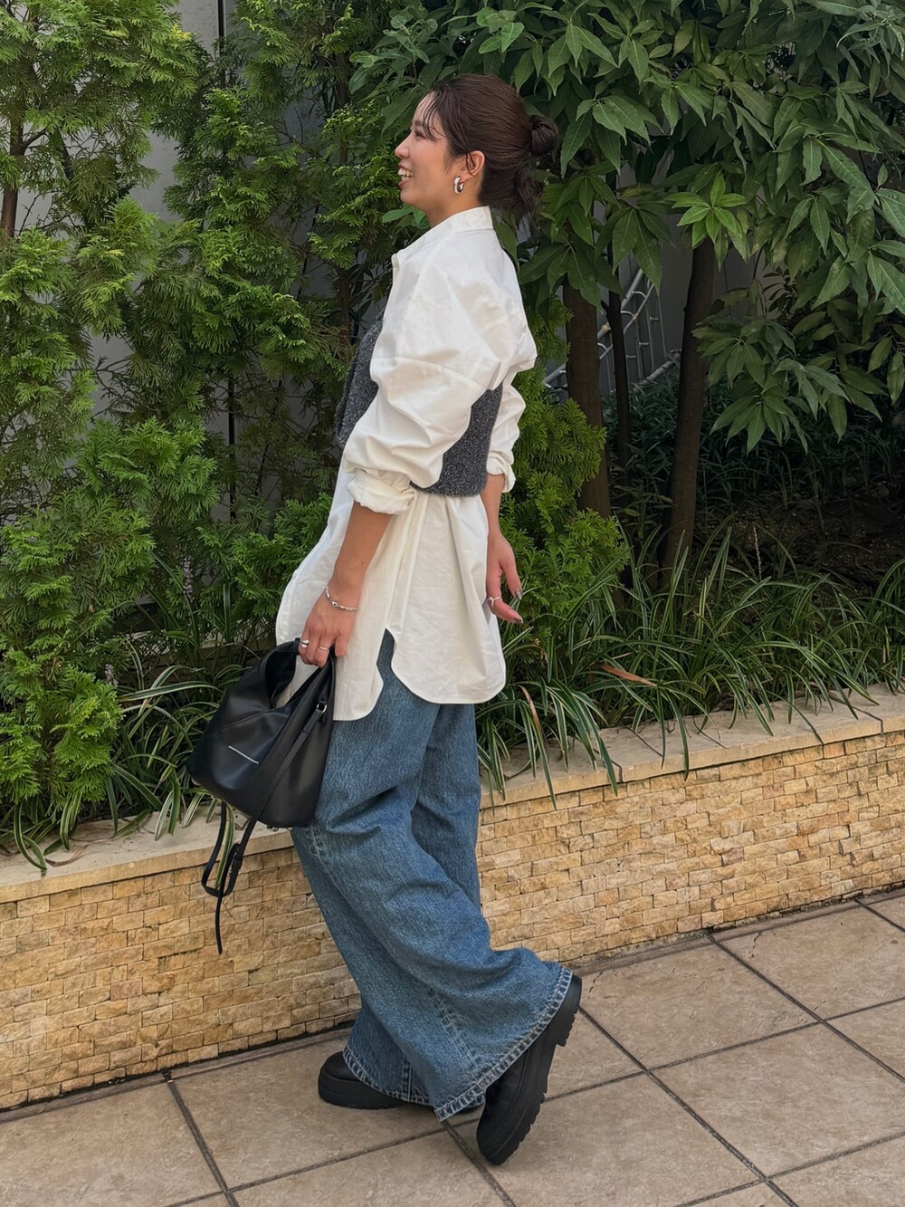 ブルー系のデニムパンツ、ホワイト系のシャツ/ブラウス、ブラック系のニット/セーターを着用したレディースの秋コーディネートの6枚目の写真