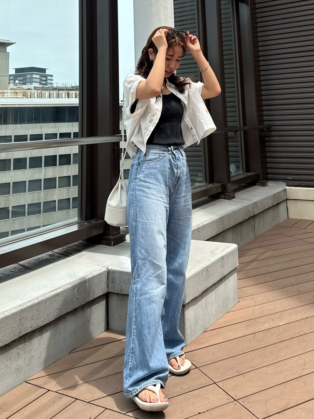 ブルー系のデニムパンツ、グレー系のTシャツ/カットソー、ホワイト系のシャツ/ブラウスを着用したレディースの夏コーディネートの2枚目の写真