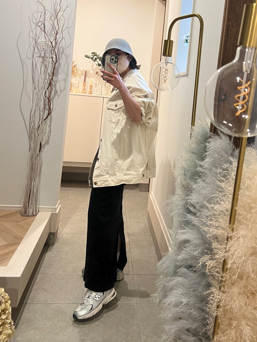 ホワイト系のデニムジャケット、ブラック系のワンピース、グレー系のハットを着用したレディースの冬コーディネートの2枚目の写真