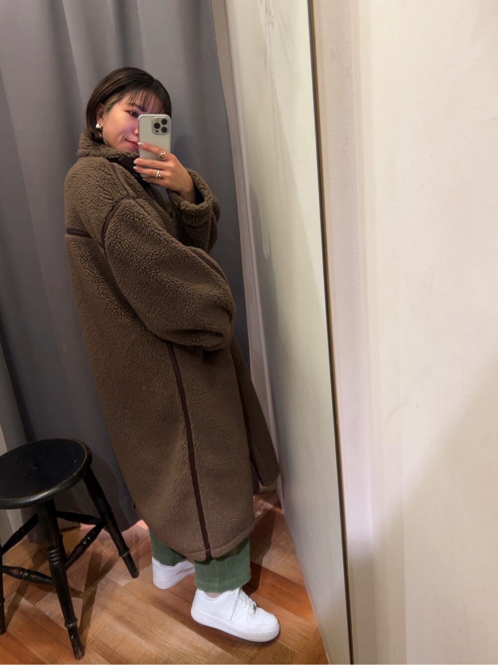 ブラウン系のムートンコート、グリーン系のその他パンツを着用したレディースの冬コーディネートの2枚目の写真