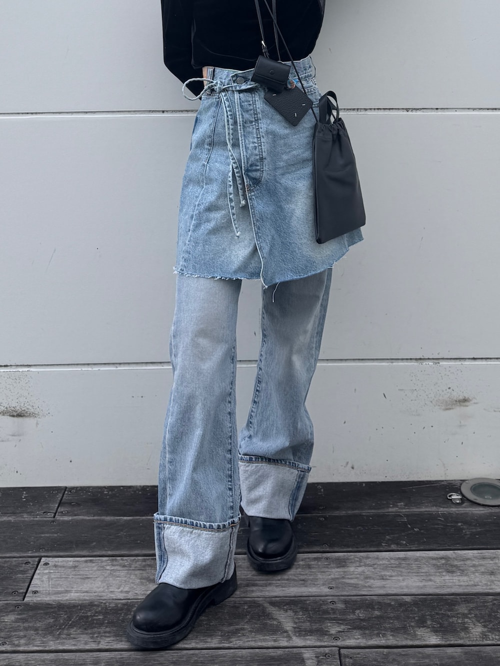 ブラック系のTシャツ/カットソー、ブルー系のスカート、ブルー系のデニムパンツを着用したレディースの冬コーディネートの3枚目の写真