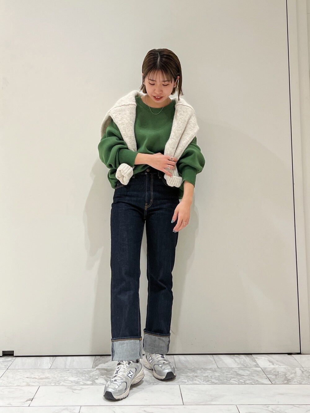 グリーン系のニット/セーター、ホワイト系のニット/セーターを着用したレディースの冬コーディネートの3枚目の写真