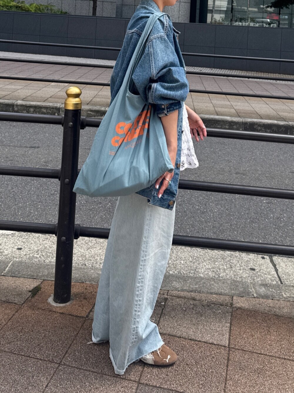 ホワイト系のシャツ/ブラウス、ブルー系のデニムパンツ、ブルー系のトートバッグを着用したレディースの夏コーディネートの3枚目の写真