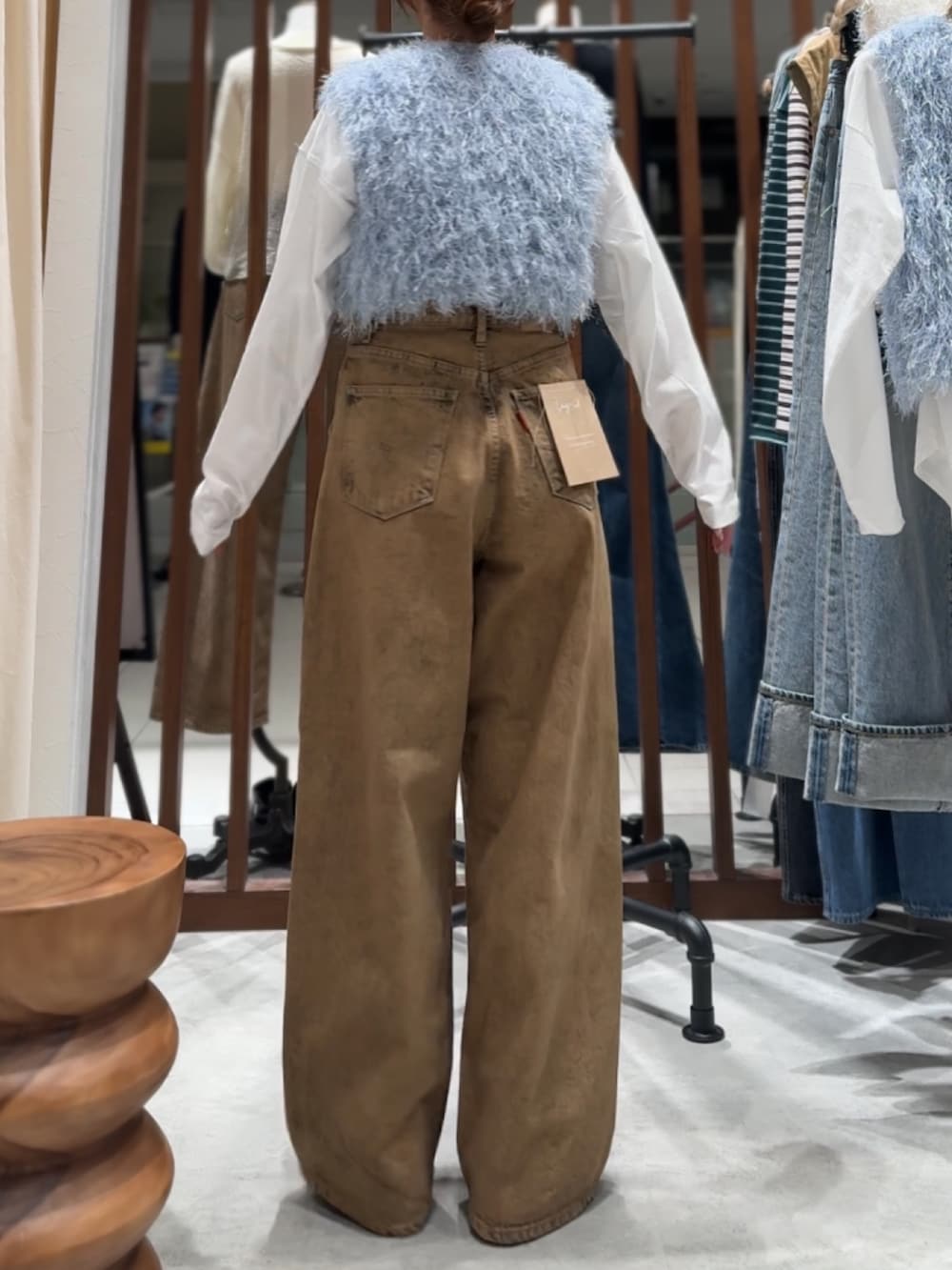 ブラウン系のデニムパンツ、ブルー系のニット/セーター、ホワイト系のTシャツ/カットソーを着用したレディースの春コーディネートの5枚目の写真